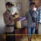 Salah satu warga saat menerima nasi bungkus dari personel Polsek Murung.